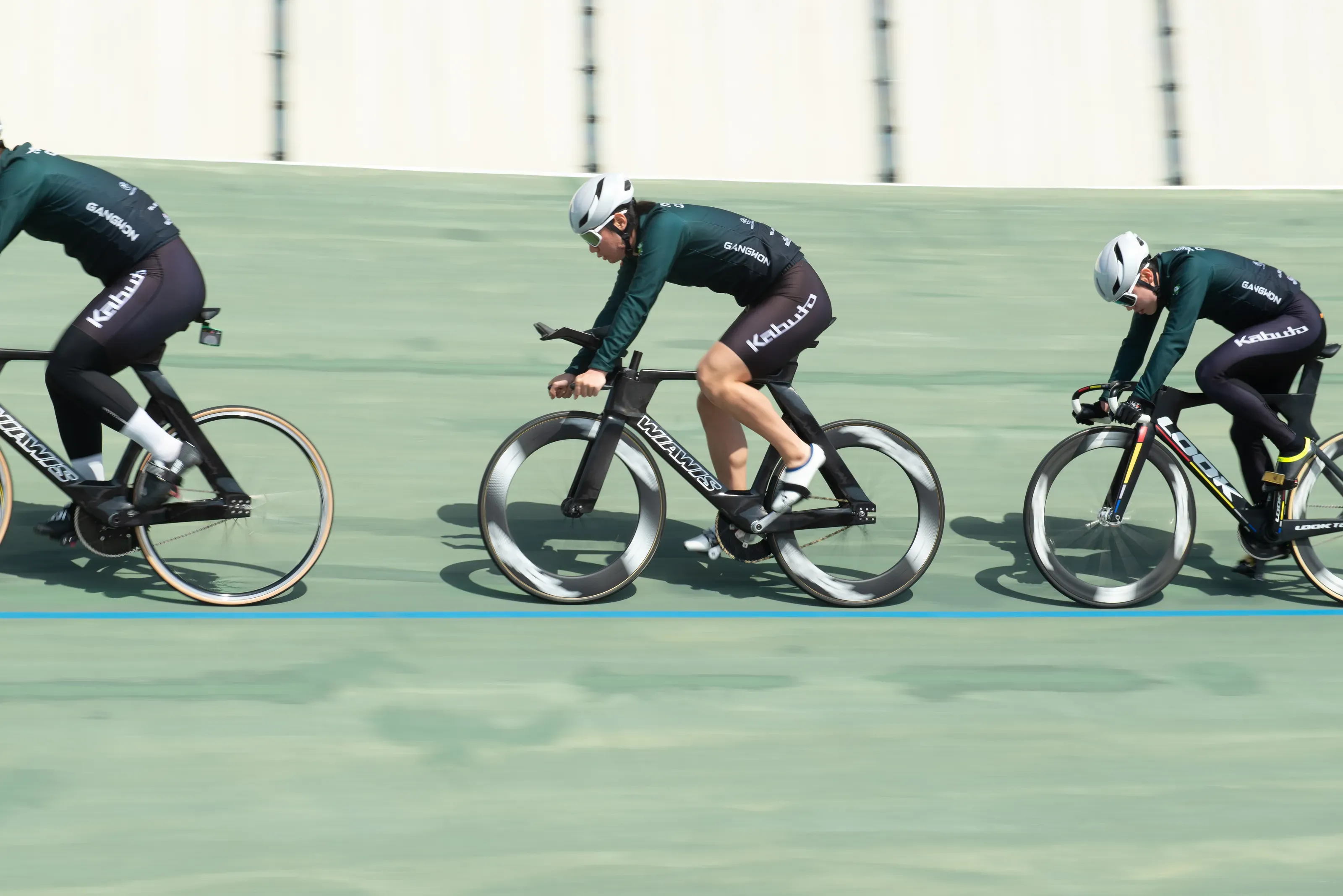 バンクを走る WIAWIS のトラックバイクの選手たち